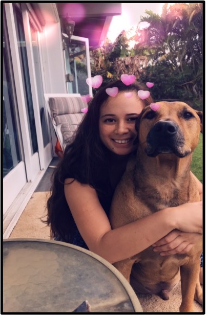 Girl holding large dog with emoji hearts around her head